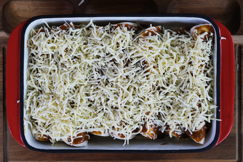 enchiladas με τυρί σε ένα εμαγιέ μαντεμένιο τηγάνι ψησίματος από χυτοσίδηρο