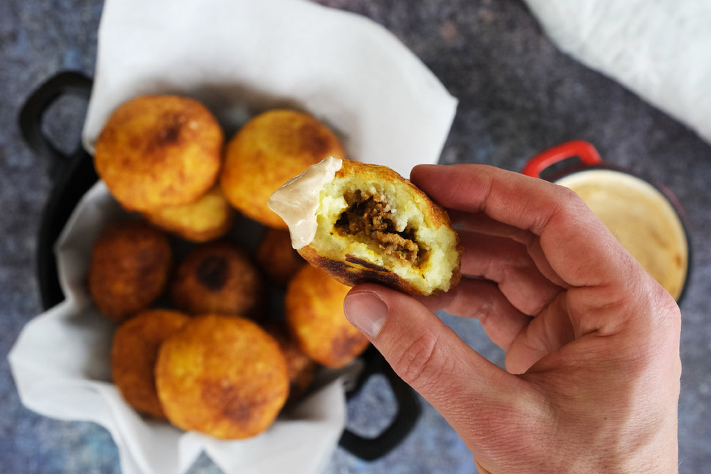 κρατώντας ένα Papas Rellenas στο χέρι