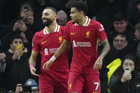 Liverpool's Luis Diaz, right, celebrates with teammate Mohamed Salah after scoring his side's sixth goal during the English Premier League soccer match between Tottenham and Liverpool at Tottenham Hotspur Stadium in London, Sunday, Dec. 22, 2024. (AP Photo/Dave Shopland)