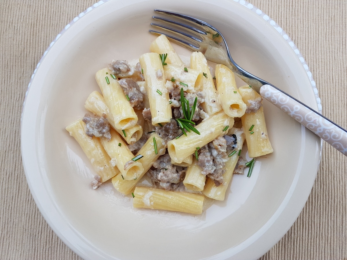 Pasta alla norcina σε ένα λευκό μπολ με ένα πιρούνι.